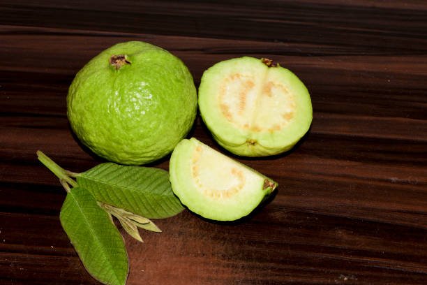 Fresh guava fruit with green leaf on the wooden table
